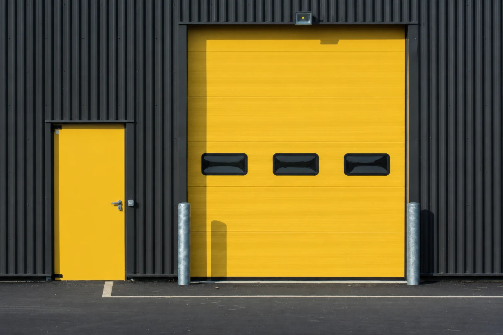 Grade-level overhead door opening directly onto pavement at an industrial building