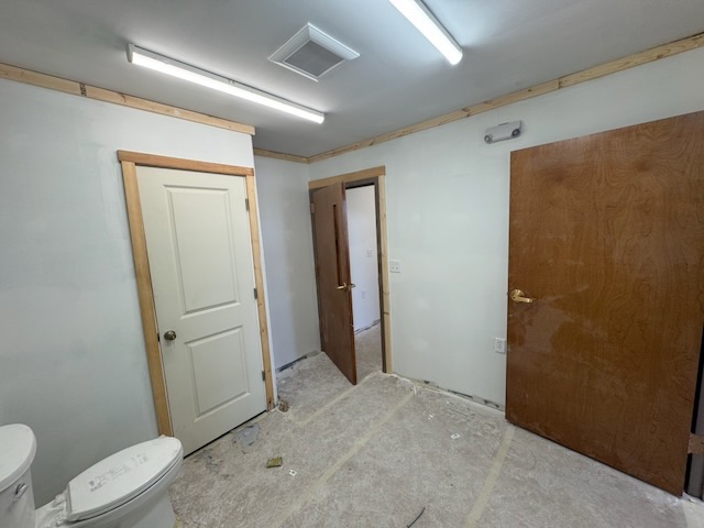 Bay 2 bathroom with toilet installed and drywall finished, looking out toward the office