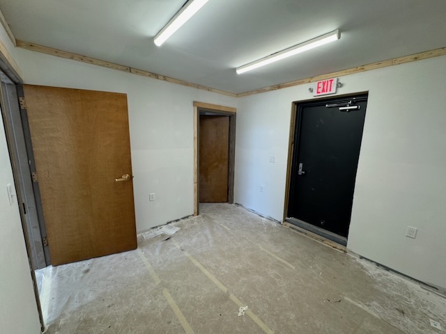 Bay 2 interior with drywall finished, a utility door, and the exit sign mounted above